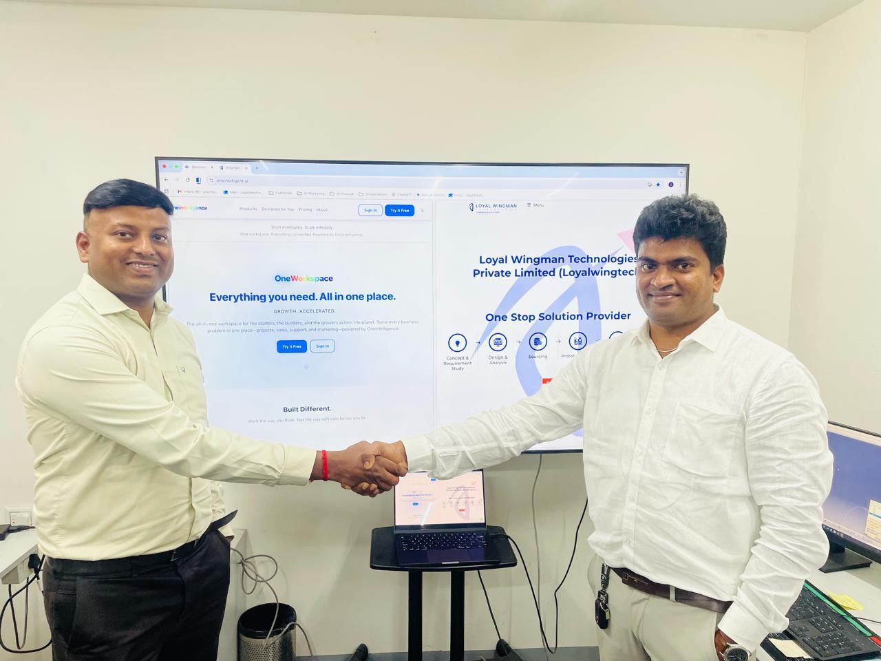 Jagadeeshwaran (right) shaking hands with our first customer at the Loyal Wingman Technologies office on launch day, with both companies' websites on the screen behind them.